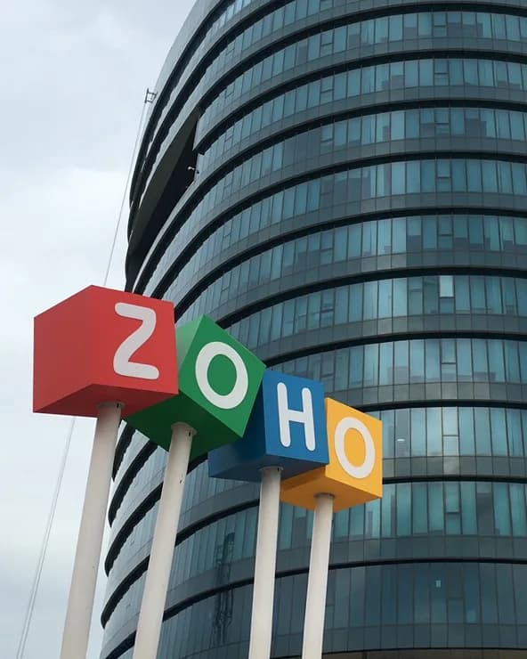 Zoho campus sign in front of a glass office building